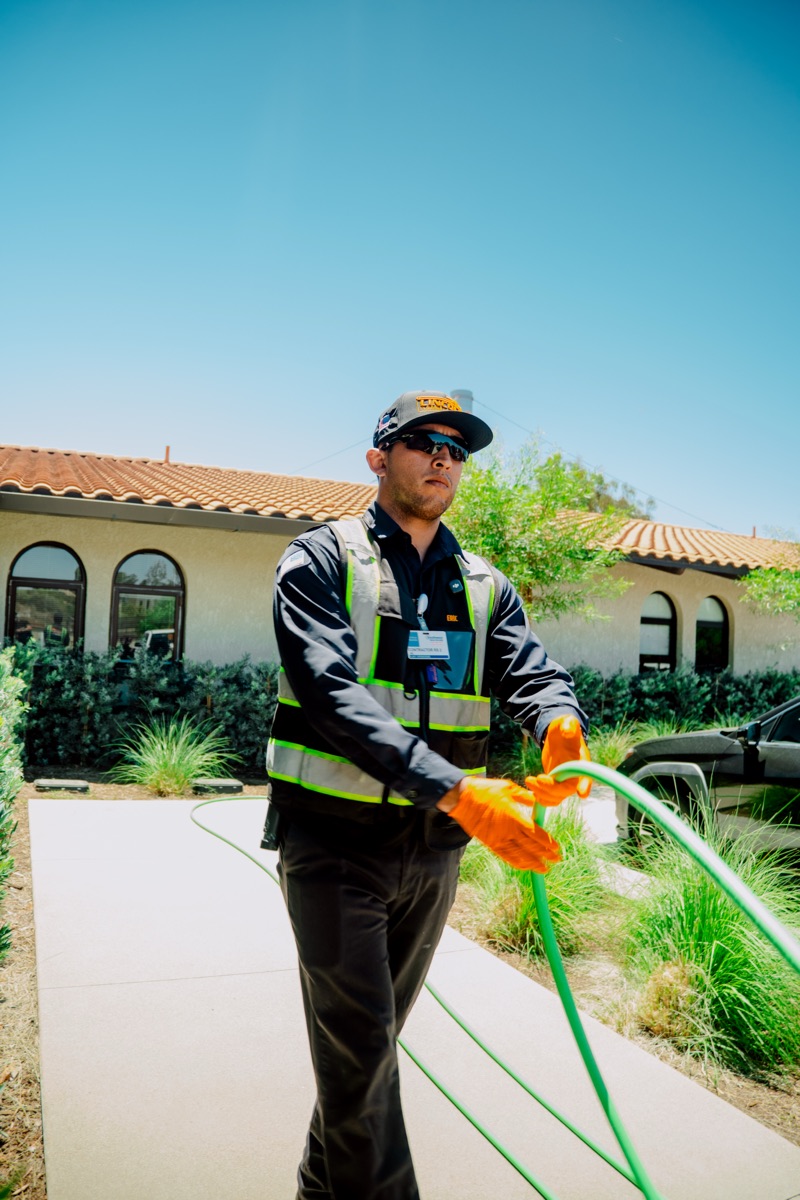 Technician running a hydrojetting hose outdoors