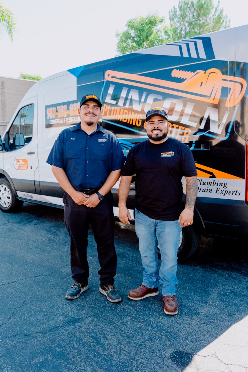 Two technicians in front of the Lincoln Plumbing & Rooter van