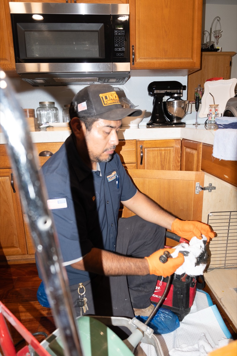 Technician clearing a kitchen drain